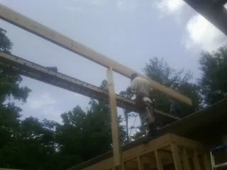Carpenter setting a ridge beam over a new addition frame — Ice Dam Removal by Roofing Brothers in Taloga