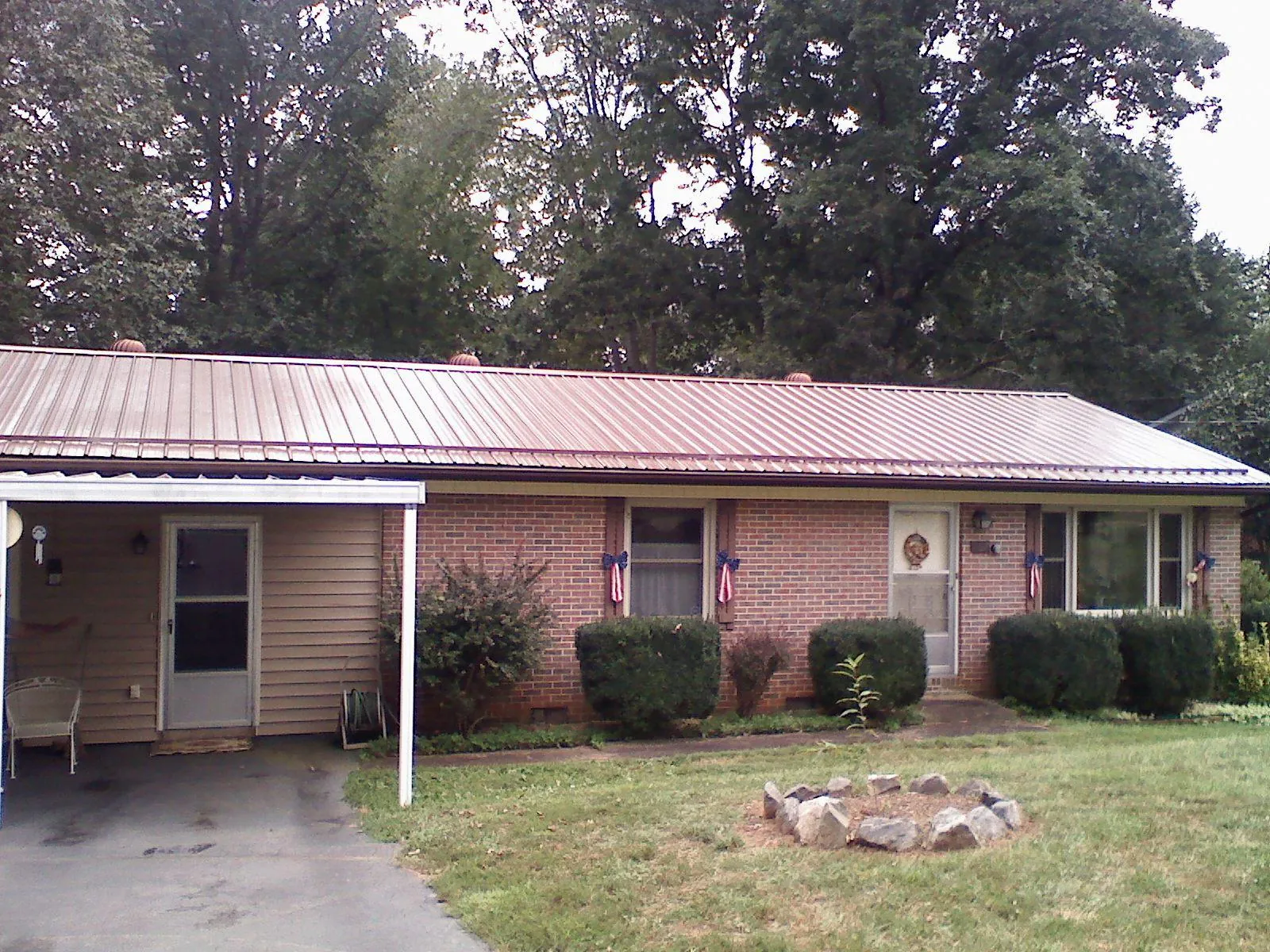 Bronze metal roof and carport on a brick ranch home — Roof Repair work by our crew in Taloga