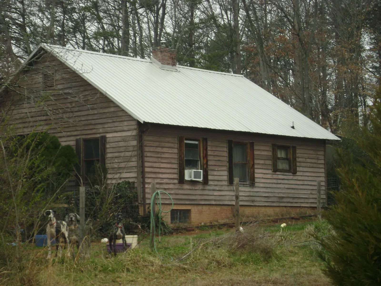 White metal roof on an old wood sided farmhouse, from a Metal Roof Installation job in Taloga